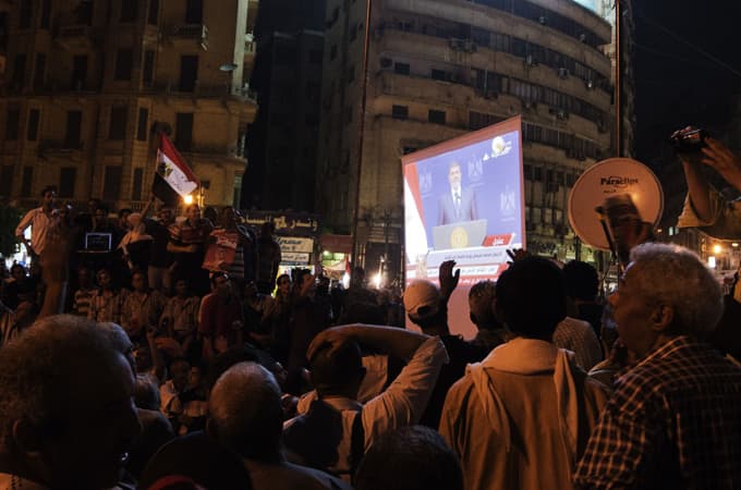 Tūkstančiai M. Morsi oponentų klausėsi jo kalbos per televiziją Kairo Tahriro aikštėje. AFP nuotr.