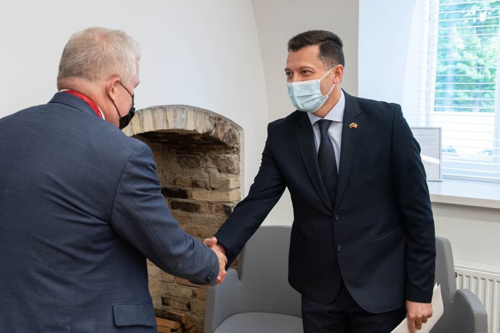 Susitikimo metu vyrai sveikinosi dr1siais delnais, o ne kumštukais. Nuotr. kam.lt